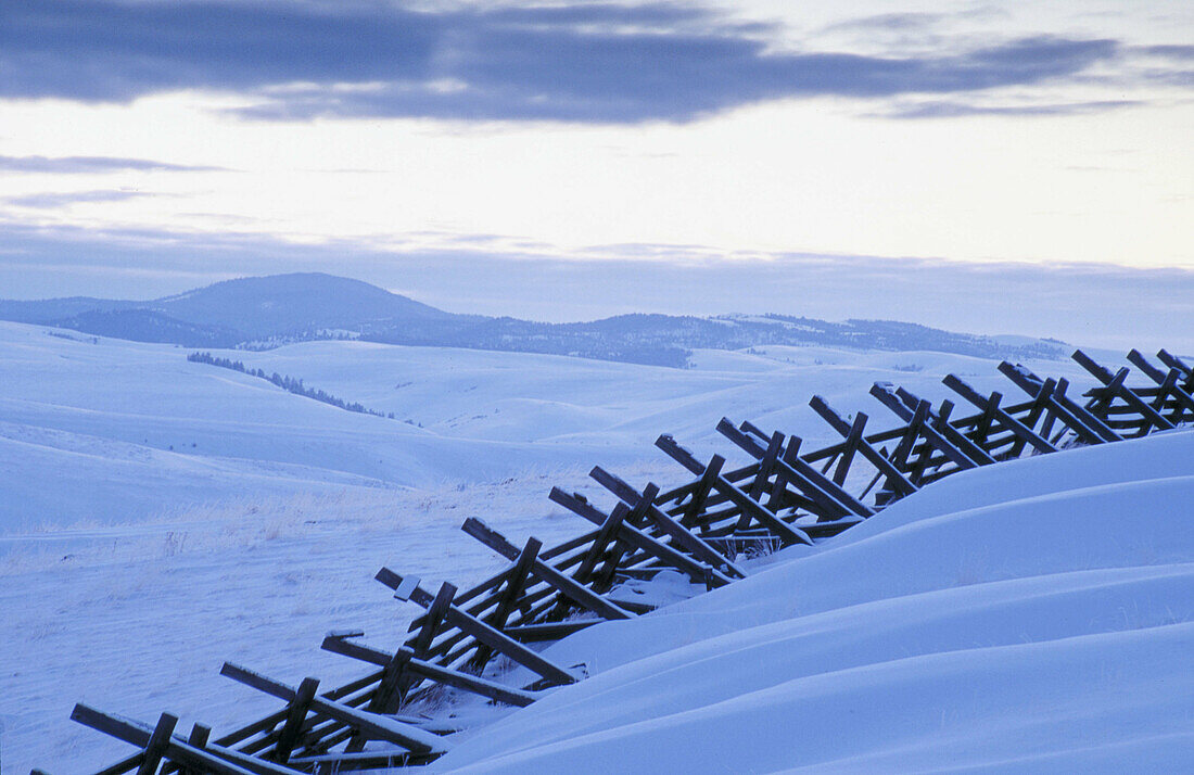 Snow fence and drifts along side a highway in Northeast Oregon. Umatilla County, Oregon, USA