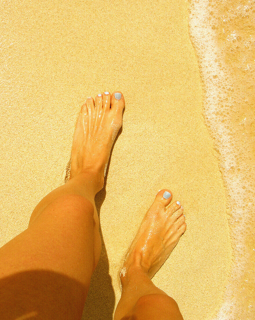 Frau mit blauen Zehennägeln am Strand