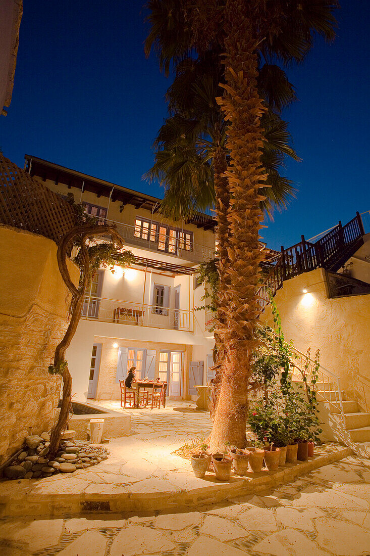 Eine Person sitzt auf der Terrasse, Ferienhaus mit Palme bei Nacht, Cyprus Villages, Agrotourismus, Kalavasos, bei Lemesos, bei Limassol, Südzypern, Zypern