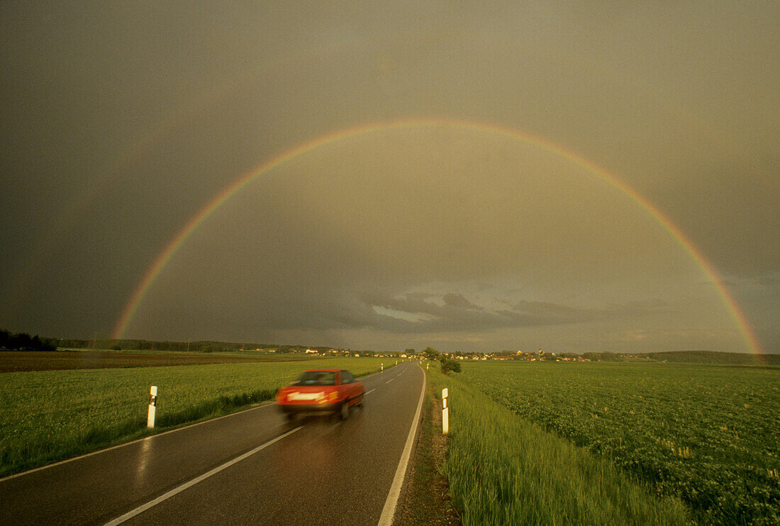 Rainbow over a country road near Glonn, Upper Bavaria, Bavaria, Germany