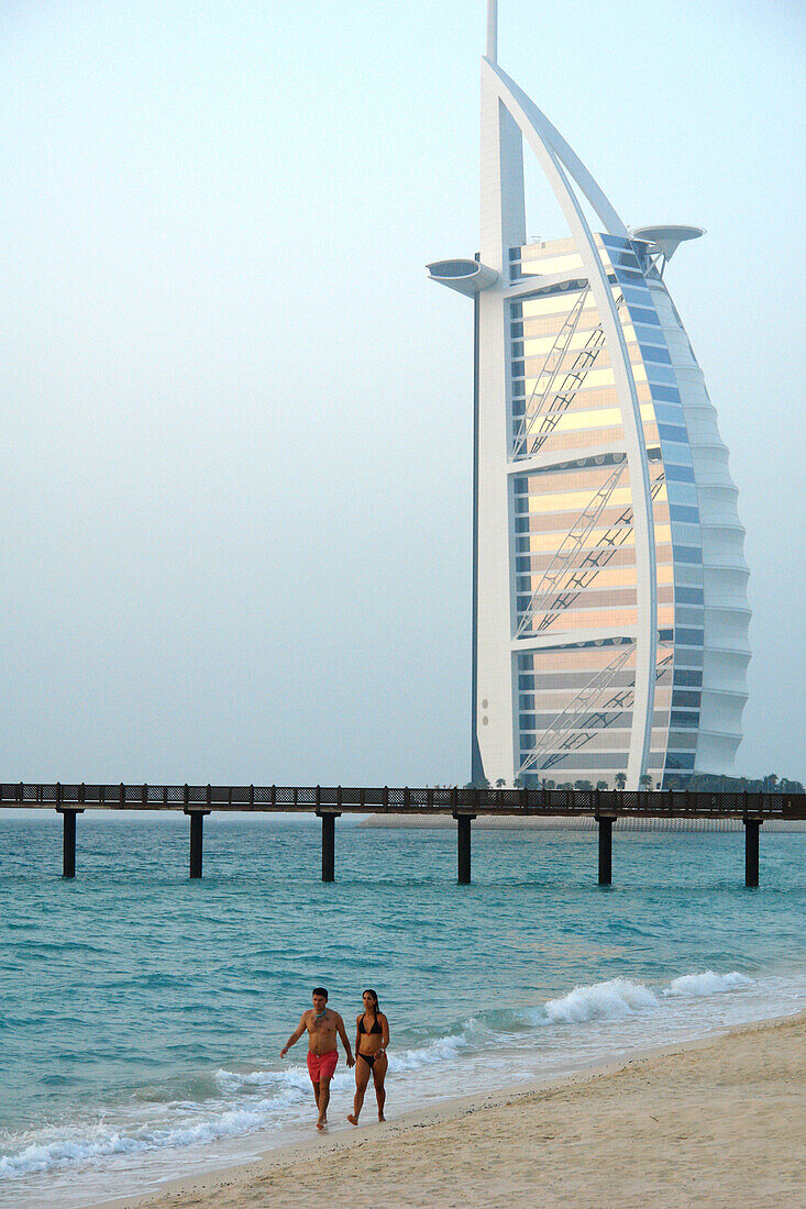 Couple strolling along the beach, View at Burj al Arab Hotel, Dubai, United Arab Emirates, UAE