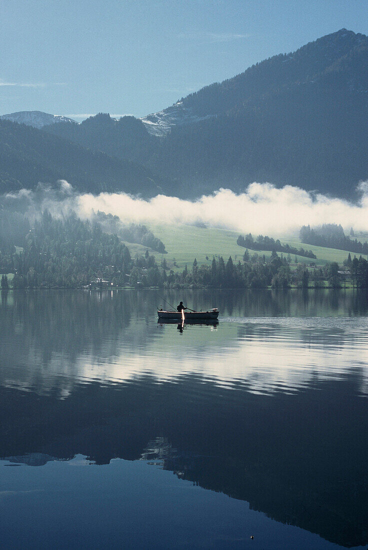 Boot und Berge spiegeln sich im Tegernsee, Bayern, Deutschland