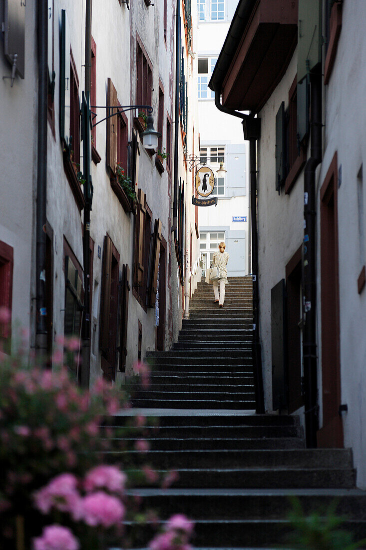 Woman walking up steps in Imberggasse, Basel, Switzerland