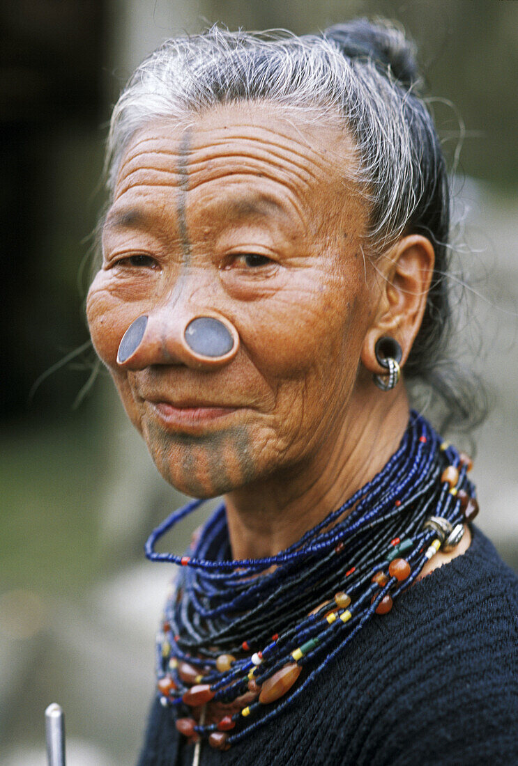Apatani woman with traditional wooden plates (Hulos), tatoo and necklace. Arunachal Pradesh. India