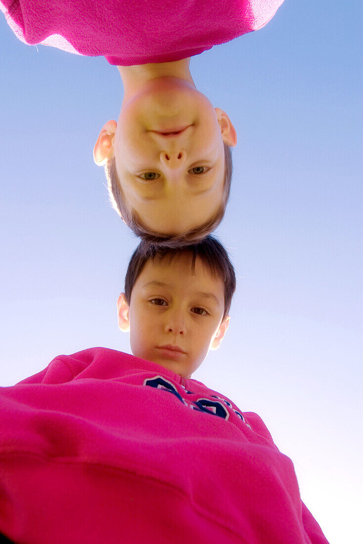 Two boys head to head looking down at camera