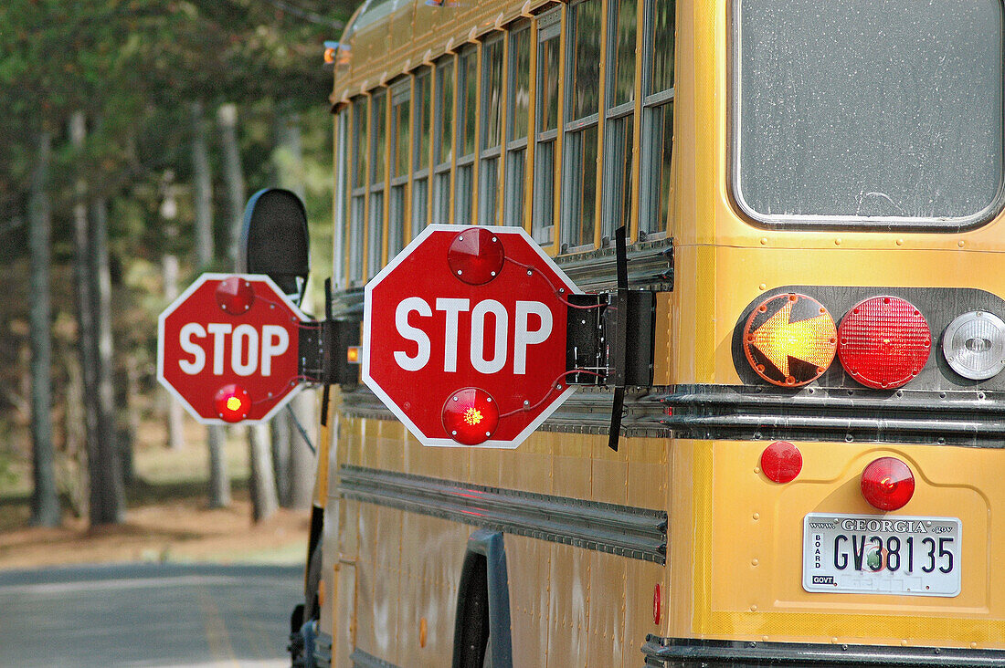 School bus with stop signs for unloading and loading students on the way to school