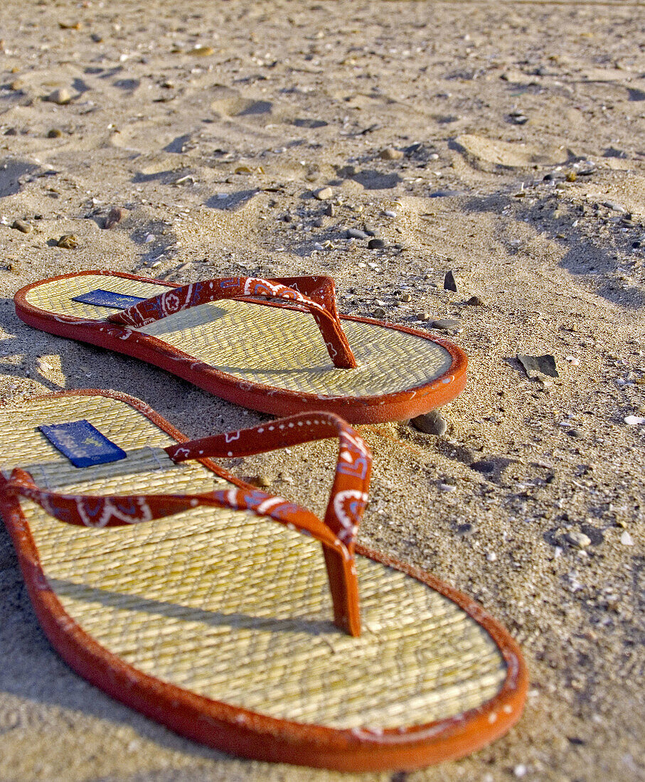  Accessories, Accessory, Beach, Beaches, Close up, Close-up, Closeup, Color, Colour, Comfort, Comfortable, Concept, Concepts, Daytime, Exterior, Holiday, Holidays, Leisure, Object, Objects, Outdoor, Outdoors, Outside, Pair, Pairs, Red, Sand, Sandal, Sanda