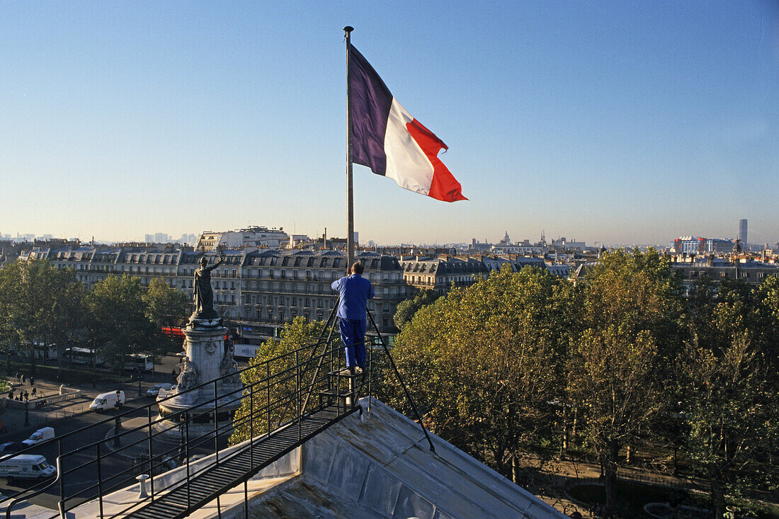 French tricolour, tricolore, French flag being hoisted on the roof of the barracks, Caserne Vérines, Place de la Republique, Paris, france