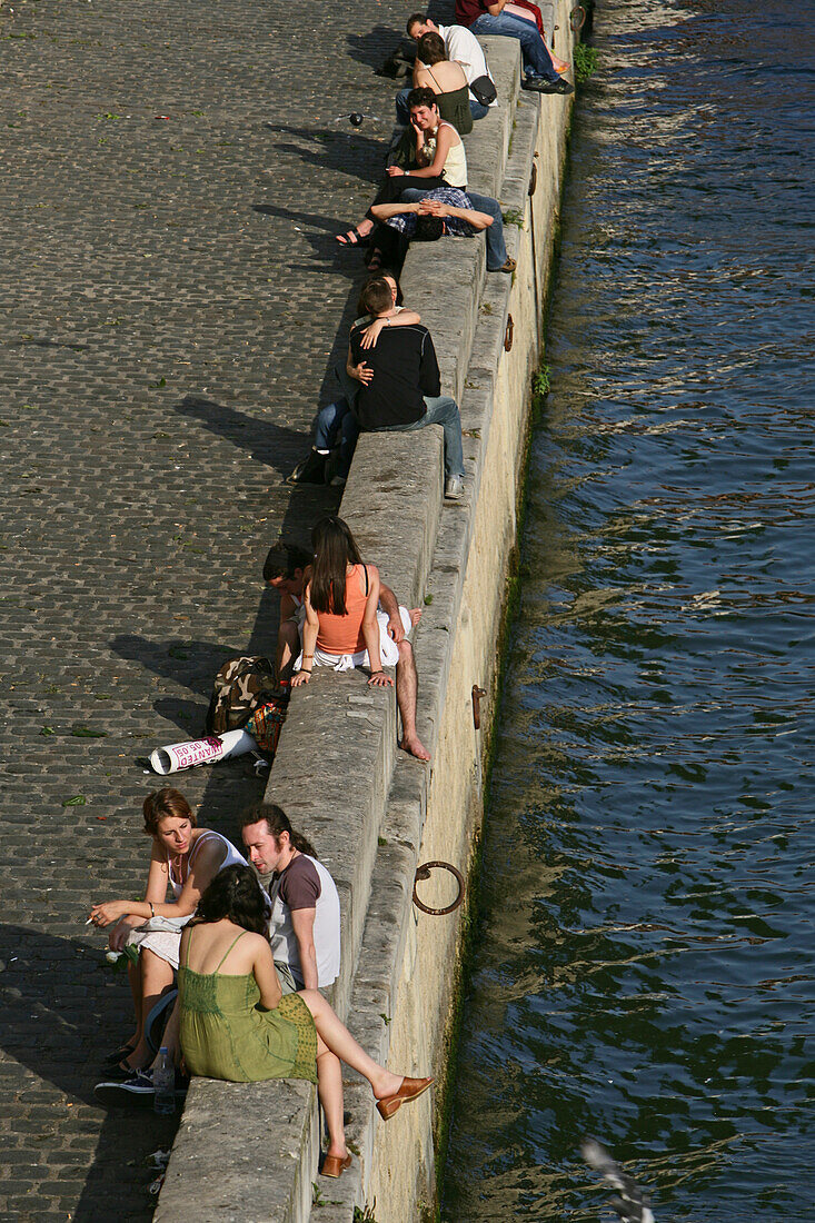 Paare treffen sich an der Kaimauer der Seine, Paris, Frankreich, Europa