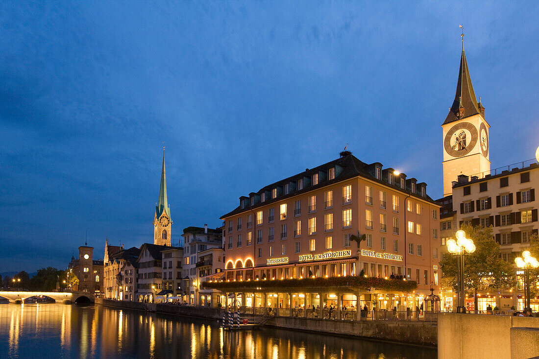 Switzerland, Zurich, old town center, river Limmat at night, left side Fraumunster church, right side St. Peters church,Hotel Storchen