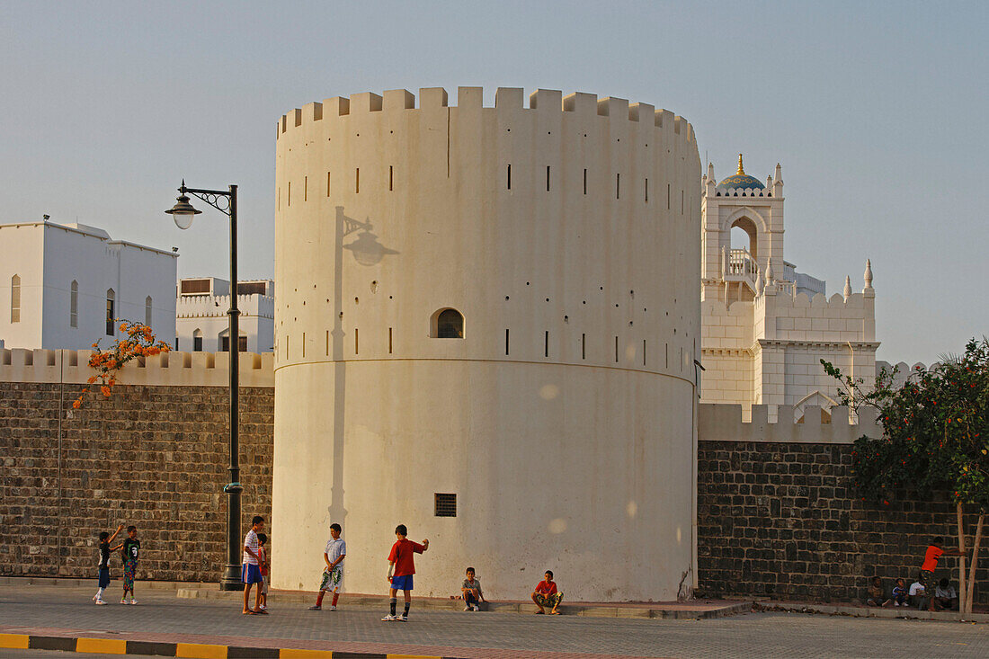 Oman Muskat Kinder spielen vor Wachturm im Regierungsviertel der Altstadt