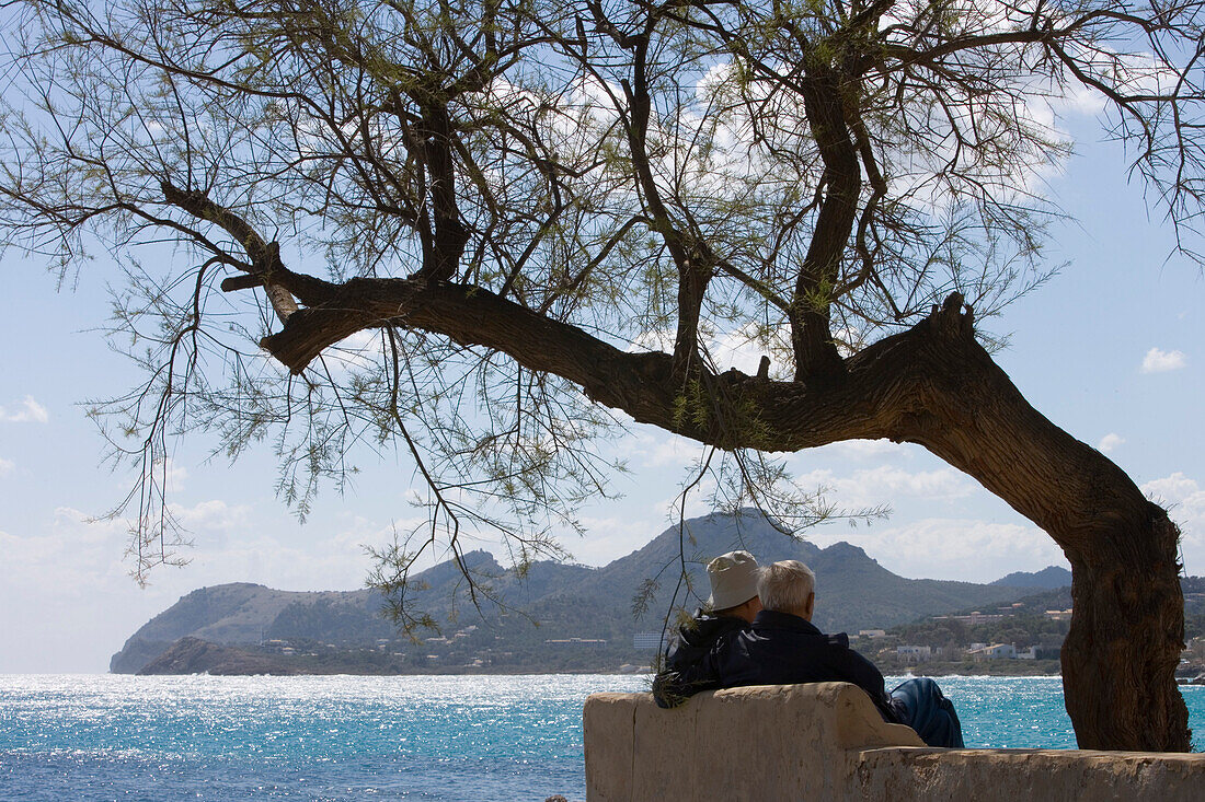 Älteres Paar auf Bank genießt Blick auf Küste, Cala Rajada, Mallorca, Balearen, Spanien, Europa