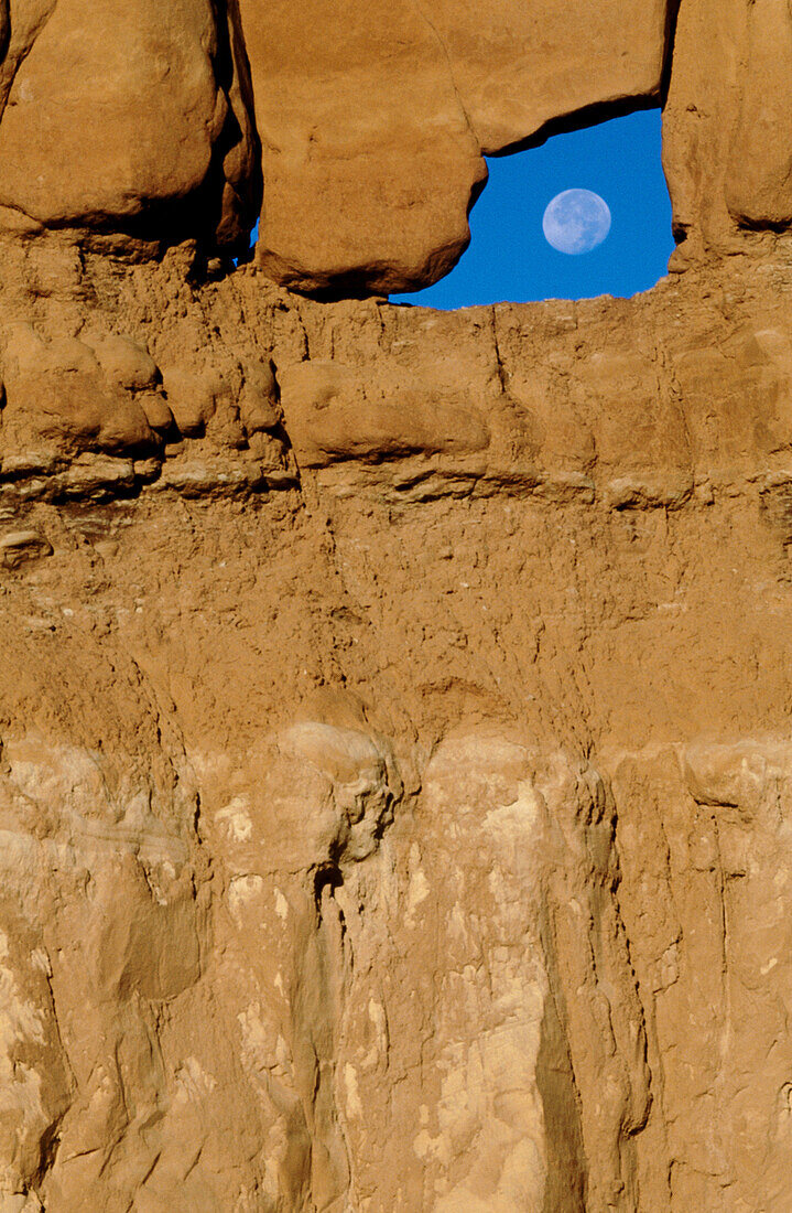 Rock hoodoos with blue sky and moon. Goblin Valley State Park. Utah, USA