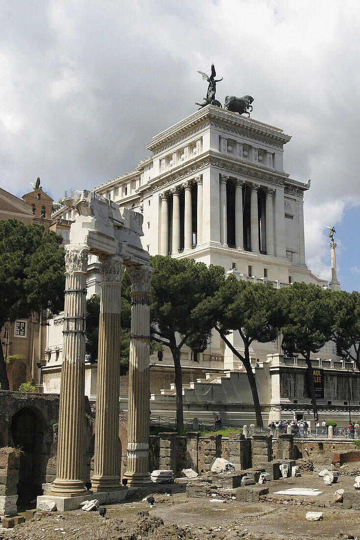 Corinthian columns on Julius Caesars forum with the monument to Vittorio Emanuele II at background. Via dei Fori Imperiali. Rome. Italy
