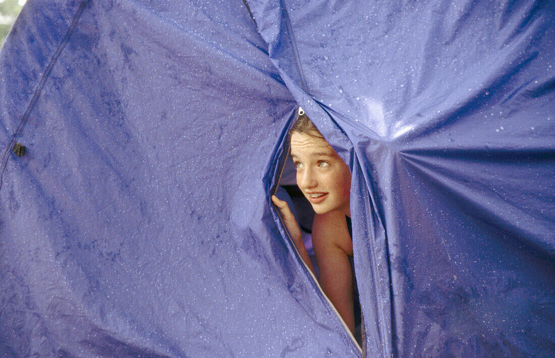 Kid in tent looking at rain