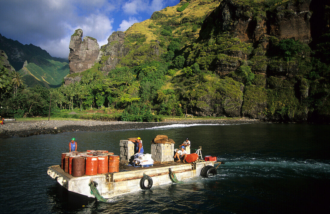 Menschen transportieren Fracht auf einem Lastkahn in der Bucht von Hanavave auf der Insel Fatu Iva, Französisch Polynesien