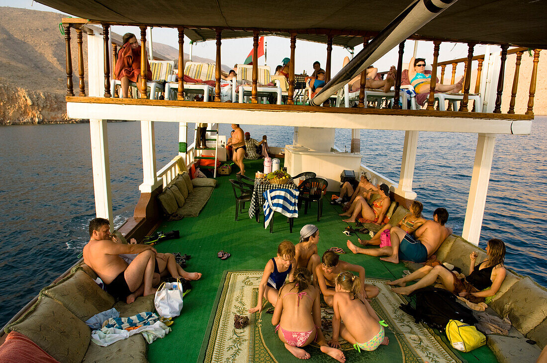 Boat with tourists, Children playing, Dhow, in the Haijar Mountains, Musandam, Oman