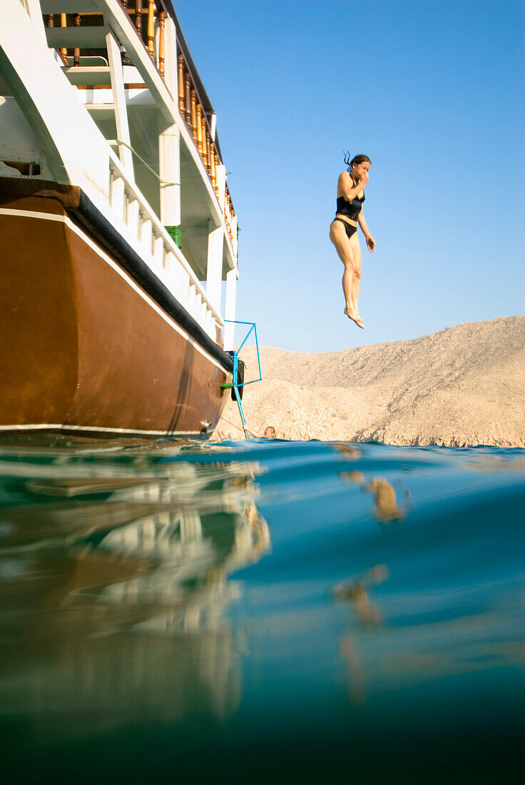 Frau springt ins Meer, Golf von Oman, Musandam, Sultanat Oman