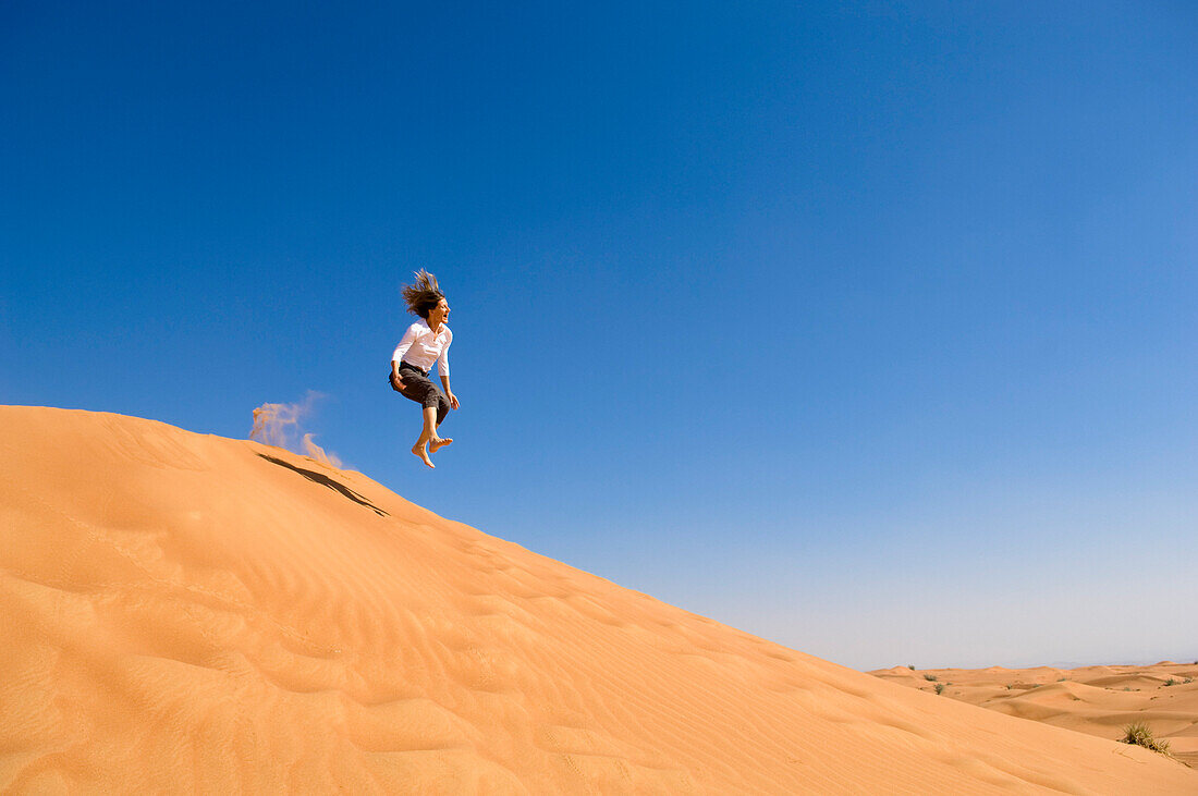 Frau springt über einen Sanddüne, Wüste, Vereinigte Arabische Emirate