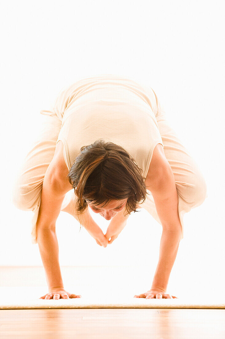 Frau mittleren Alters macht Yoga (Kranich), Yogastudio in Linz, Österreich