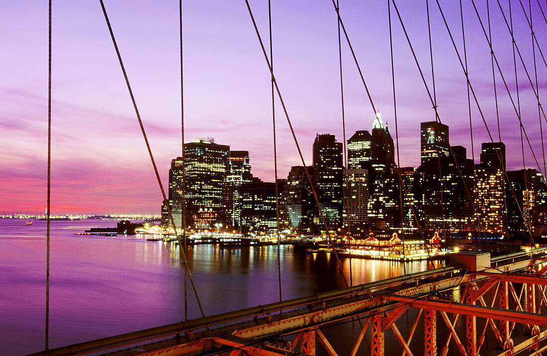 View of Lower Manhattan skyline from the Brooklyn Bridge at night. New York City, USA