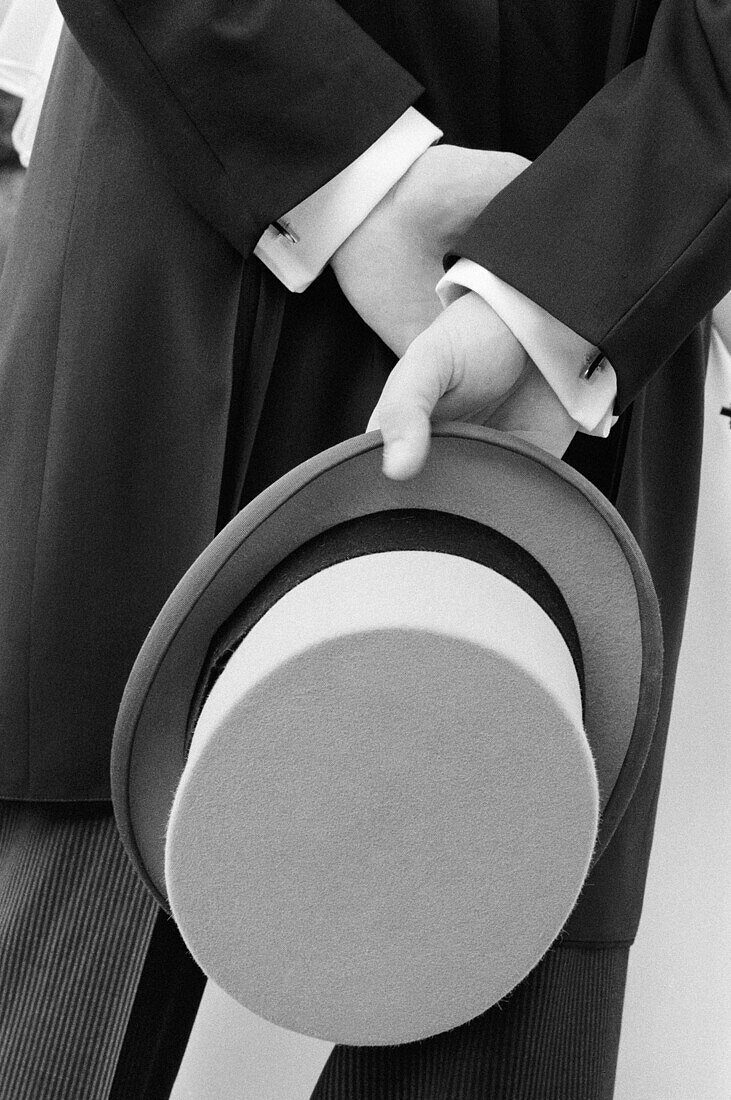 Accessories, Accessory, Adult, Adults, Anonymous, B&W, Back view, Black-and-White, Ceremonies, Ceremony, Contemporary, Daytime, Detail, Details, Dressed up, Elegance, Elegant, Exterior, Hand, Hands, Hat, Hats, Headgear, Hold, Holding, Human, Male, Man, Ma