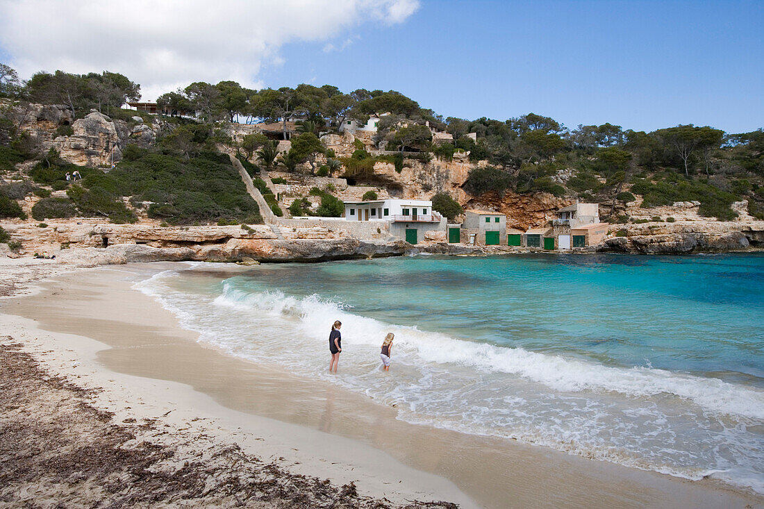 Junge Mädchen planschen am Strand der Cala Llombards Bucht, Cala Llombards, Mallorca, Balearen, Spanien, Europa
