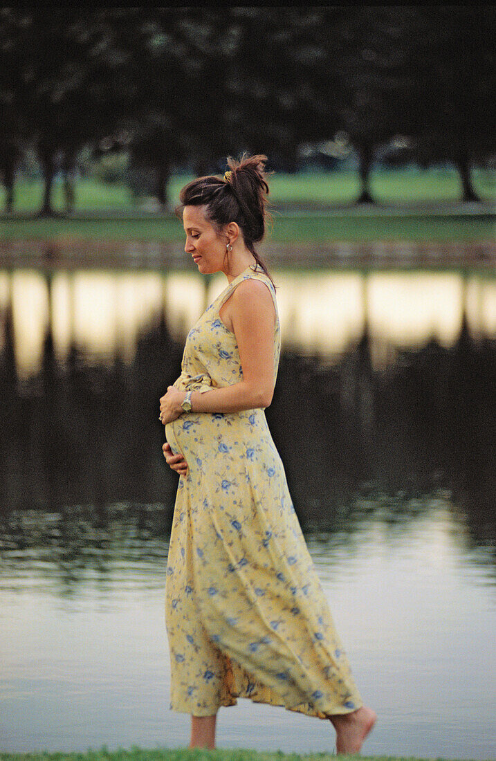 pregnant woman walking by a lake