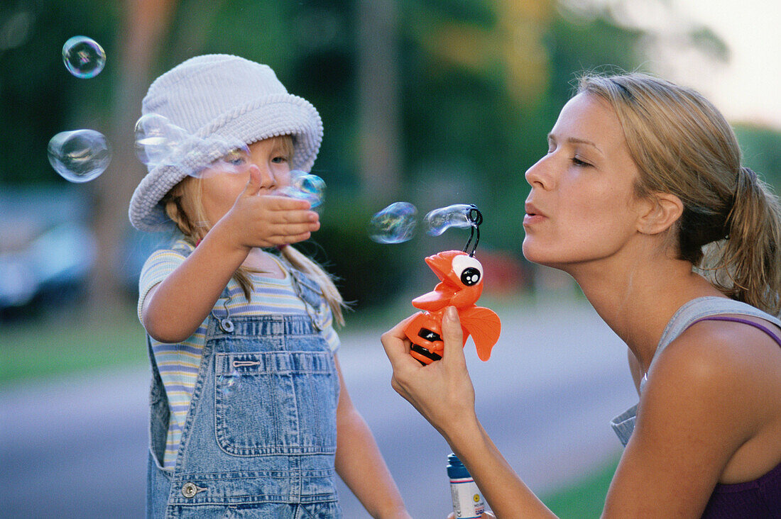 mother and daughter blowing bubbles
