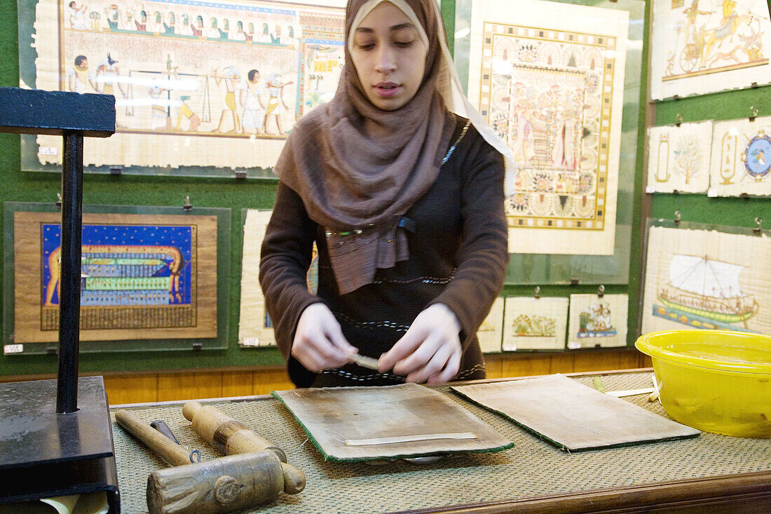 Woman showing the process to make papyrus for paintings. Cairo. Egypt.
