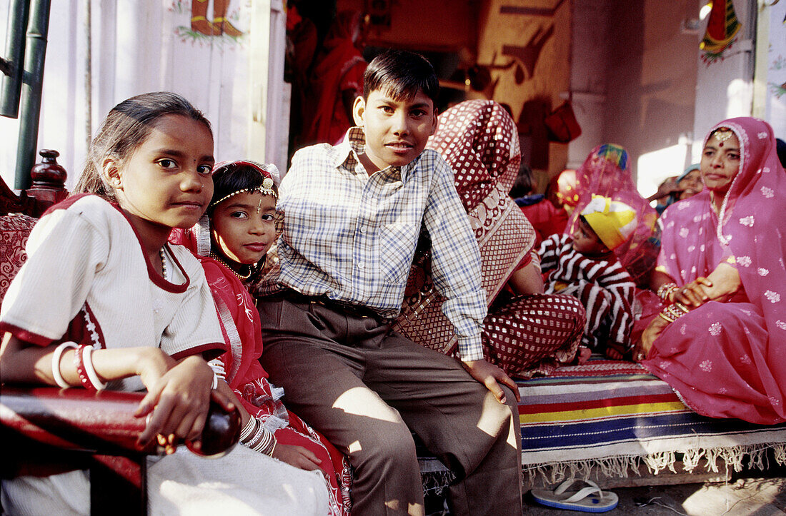 Indian family all dressed up for a wedding, women in colourful sari and children in clean formal clothes. Rajasthan. India.