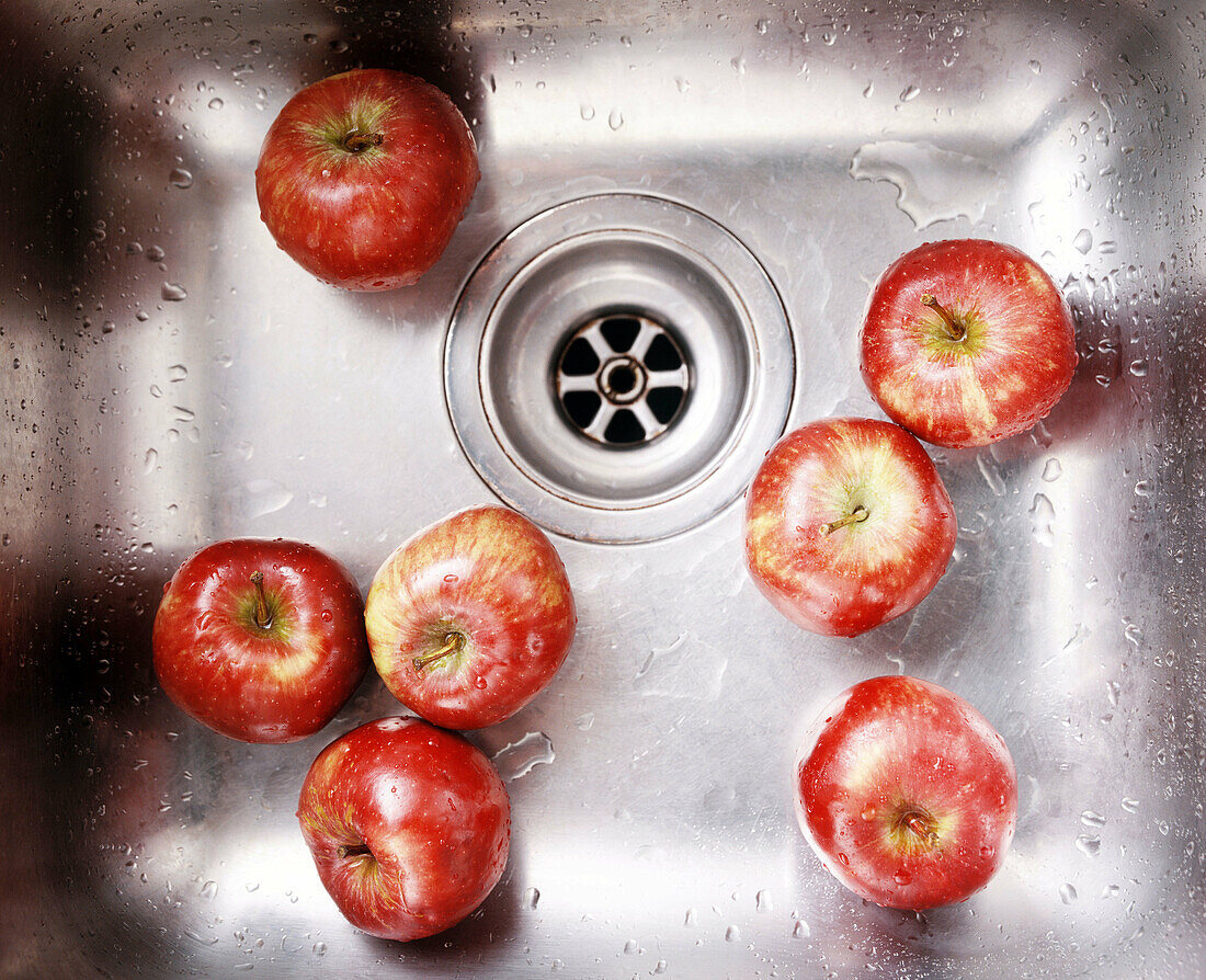 Metal sink with washed red apples