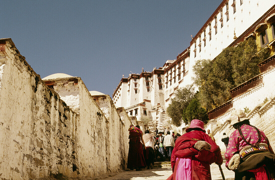 Two elderly women climbing to the top of the Potala palace in Lhasa, Tibet, China, Asia.