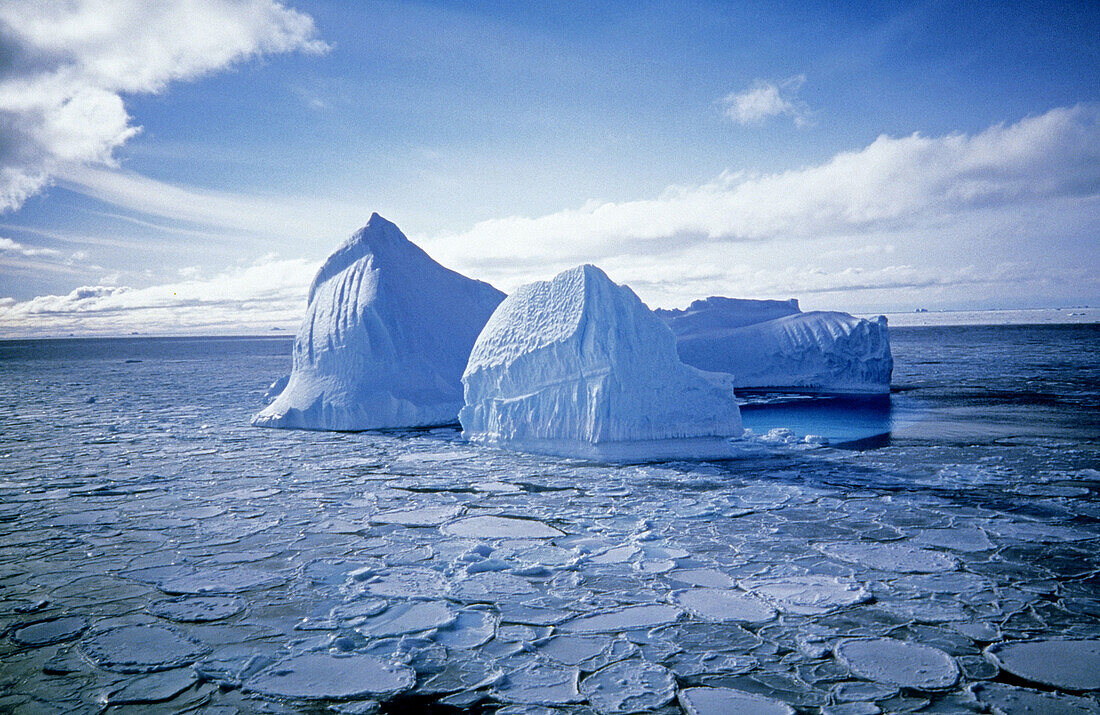 Iceberg floating in the Ross Sea: the ice surrounding it is pancake ice, its new ice and shaped like pancakes due to swells and waves beating the ice together, Antarctica