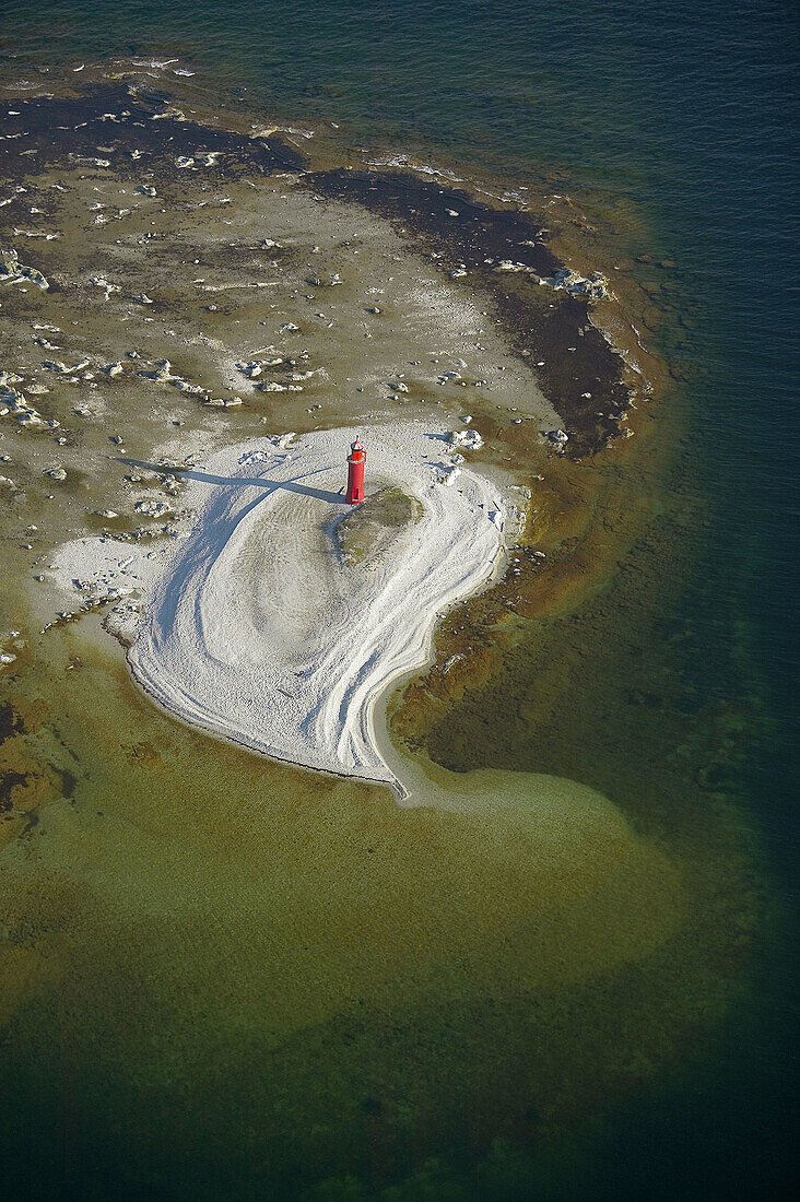 Red light house on small island and sea, aerial view. Gotland. Sweden.
