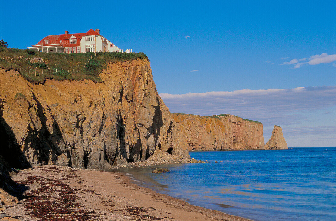 View of beach and house on cliff. Percé. Gaspésie. Quebec. Canada.