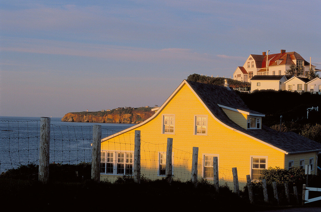 Yellow and white houses at sunrise. Percé. Quebec. Canada.