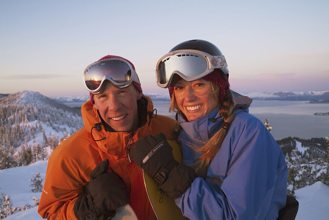 A snowboarding couple stands on the summit of Diamond Peak Ski Resort. Nevada. USA