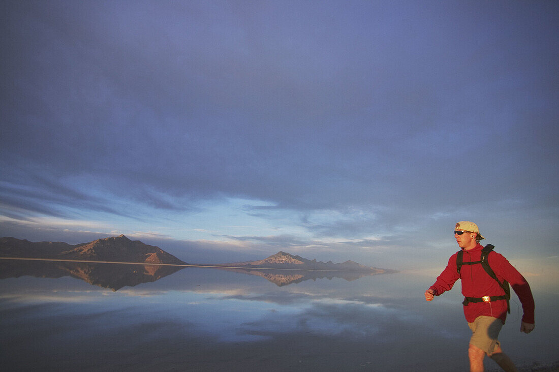 A man hikes on the Bonneville Salt Flats while listening to an MP3 player.