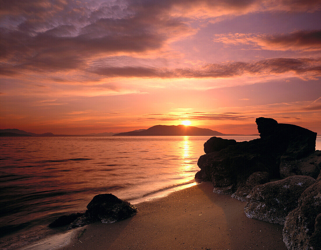 Sunset over Samish Bay from Larrabee State Park, San Juan Islands in the distance. Washington, USA