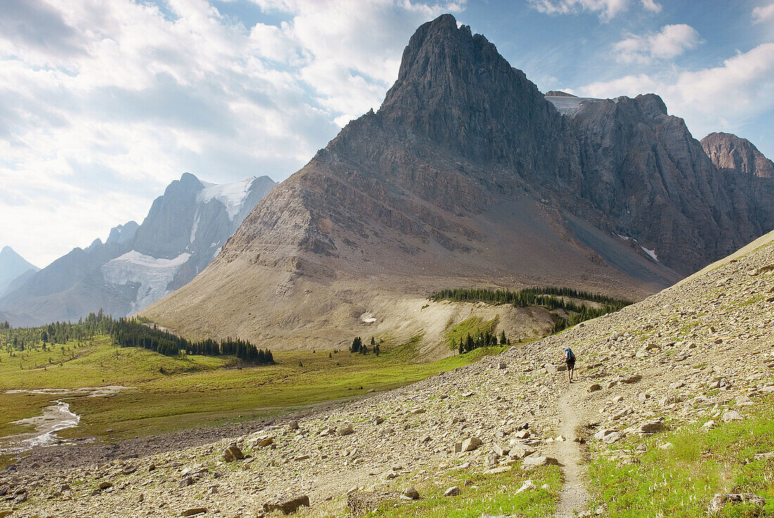 Backpacker approaching Mount Gray 3000m (9843) and Wolvereine Pass, Kootenay National Park. British Columbia. Canada