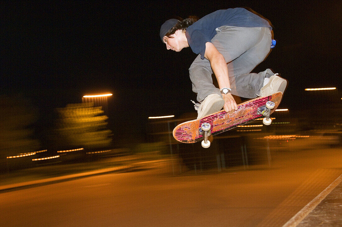 Teenage boy skateboarding at dusk
