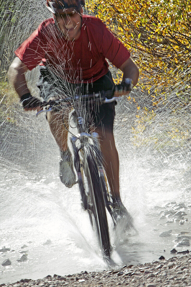 Man splashing through water on a mt. biking in Sun Valley, Idaho. USA