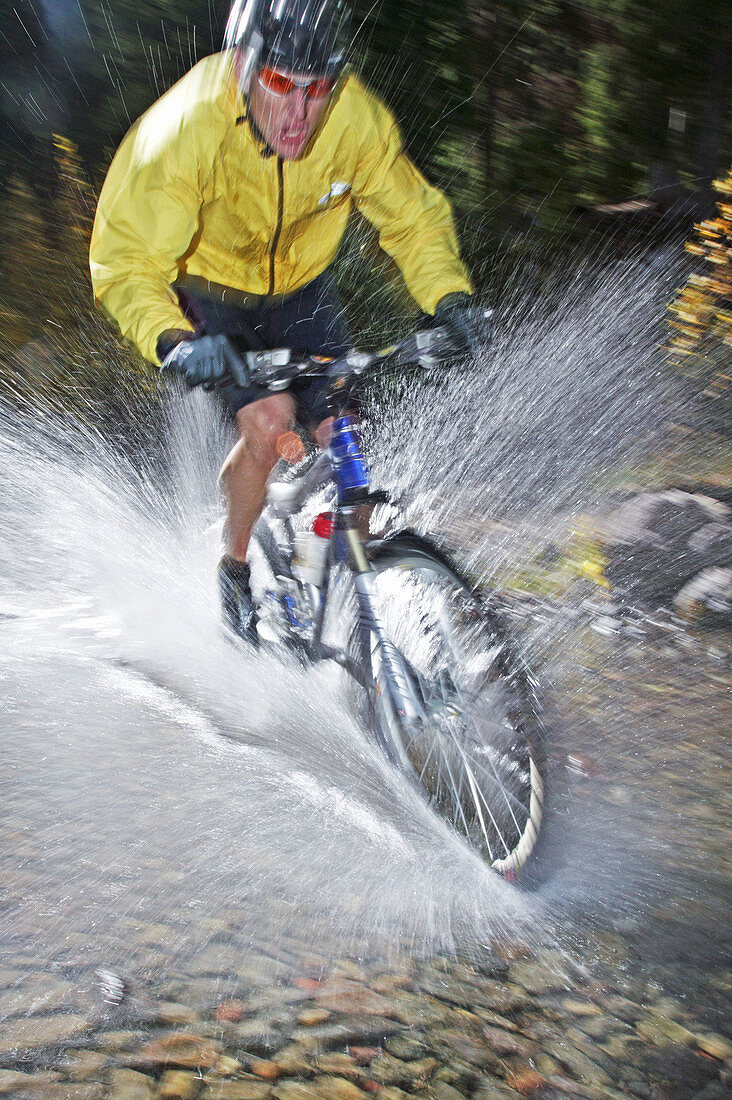 Man splashing through water on a mt. biking in Sun Valley, Idaho. USA
