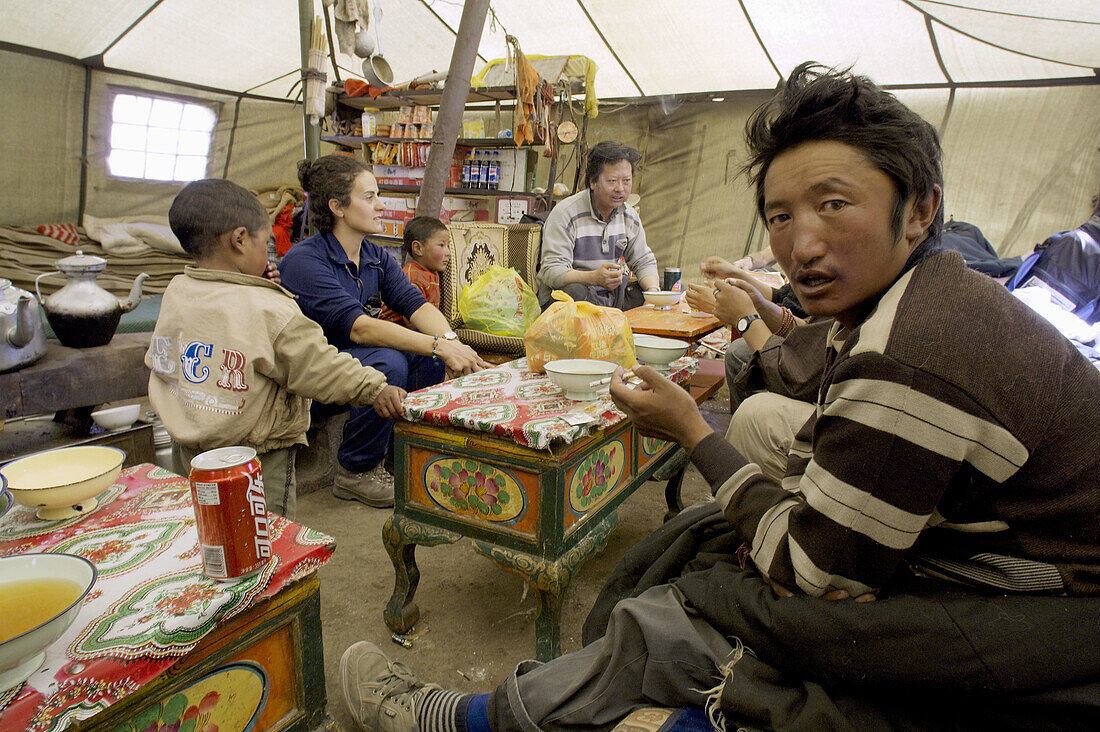 A western woman chat with tibetan nomad in a tent in the lha-chu valley on the sacred kora trail around mount Kailash. Ngari prefecture. Tibet. China