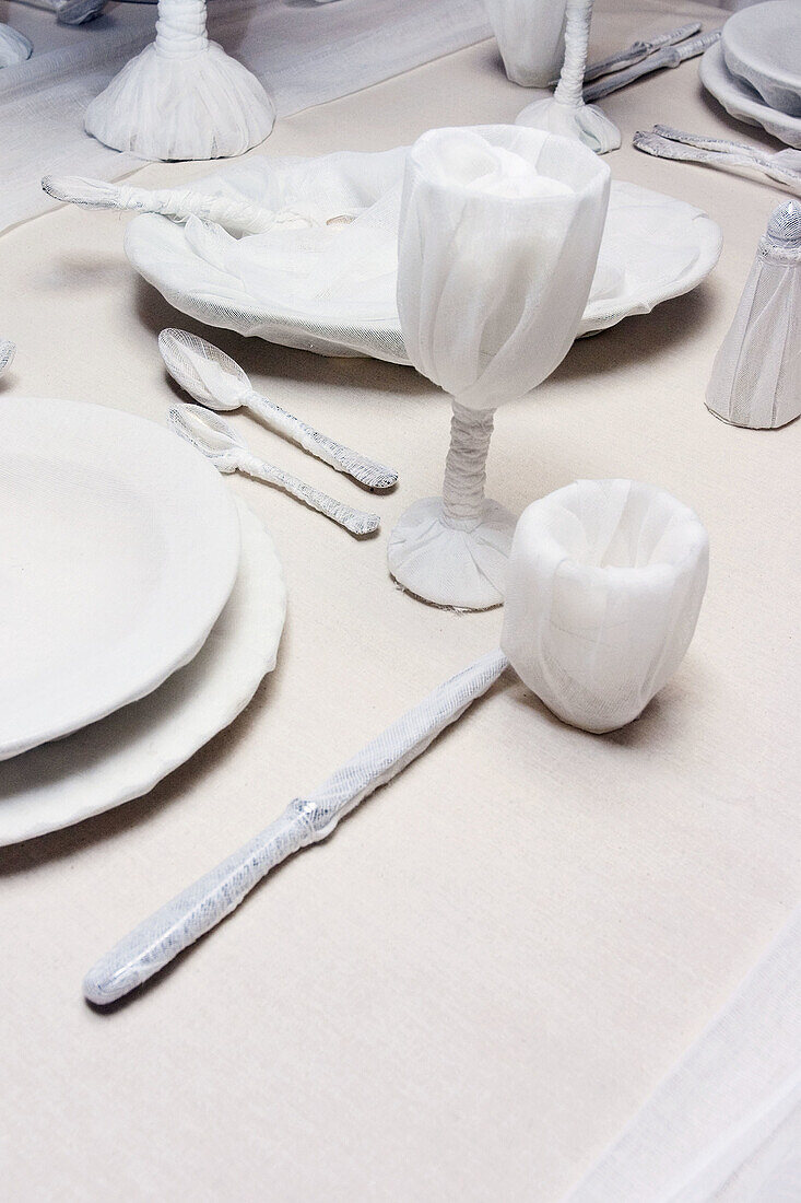 Dinner service wrapped in white linen.