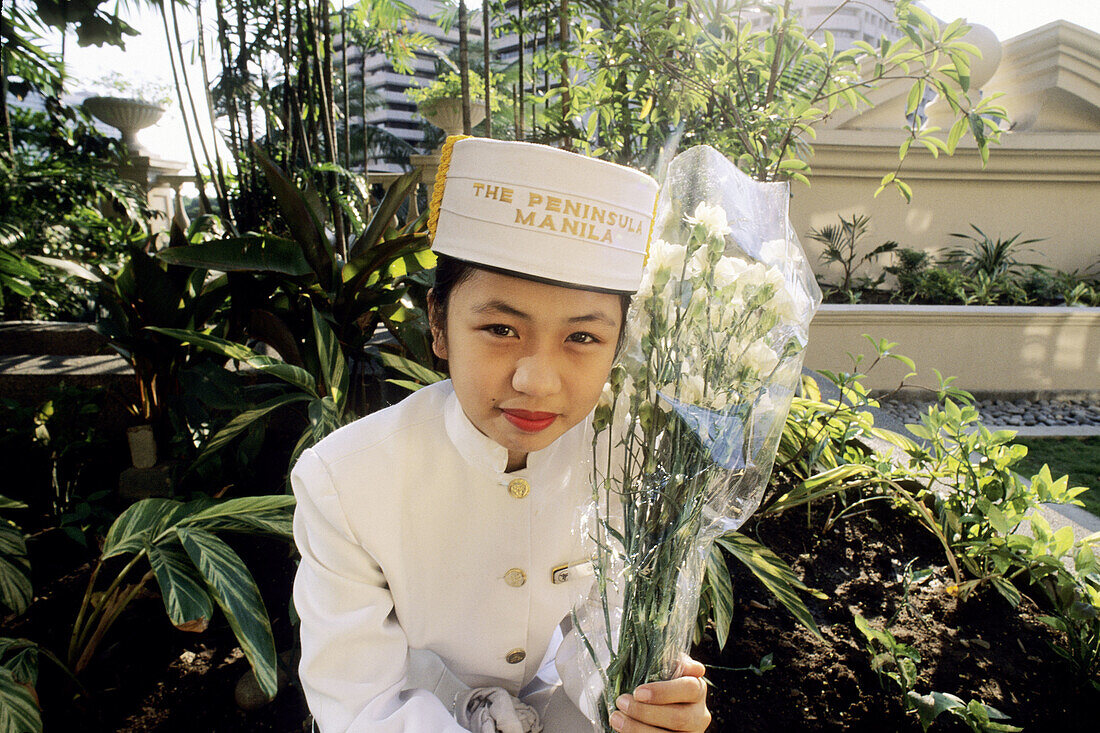 Girl in uniform holding flowers in Manila, Philippines