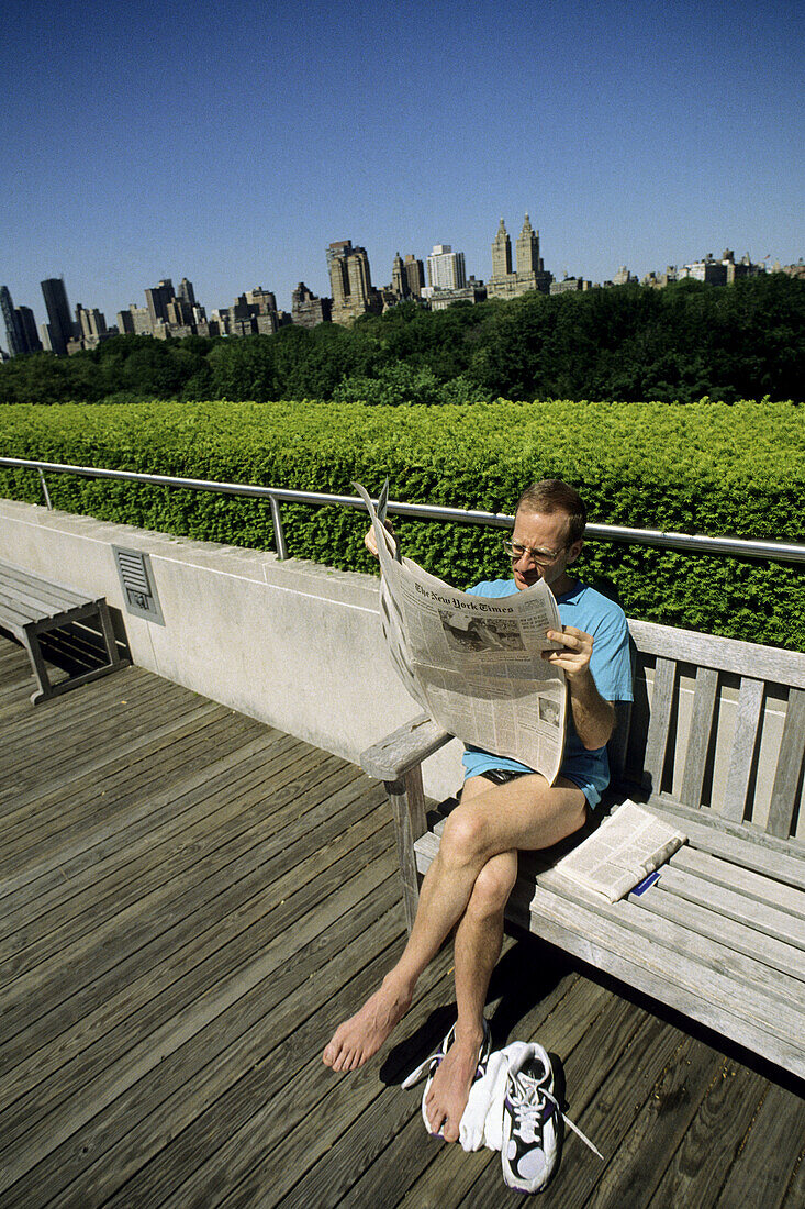 Man reading newspaper in Central Park, New York City. USA