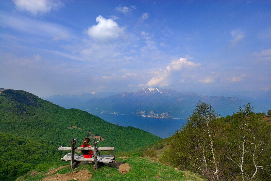 junge Frau auf Bank am Monte Gambarogno, Blick auf  den Lago Maggiore, Tessin, Schweiz