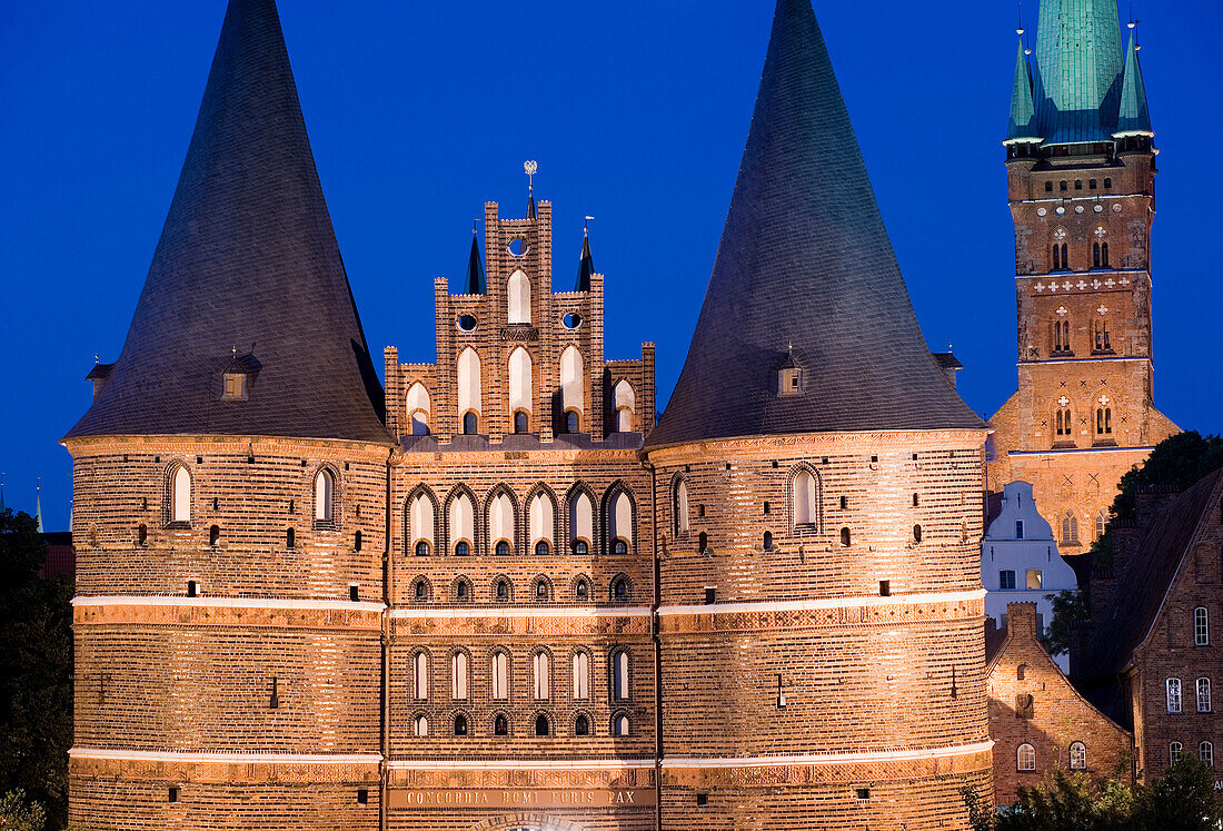 Holstentor (Holsten Gate) and St. Peter church at night, Lubeck, Schleswig-Holstein, Germany